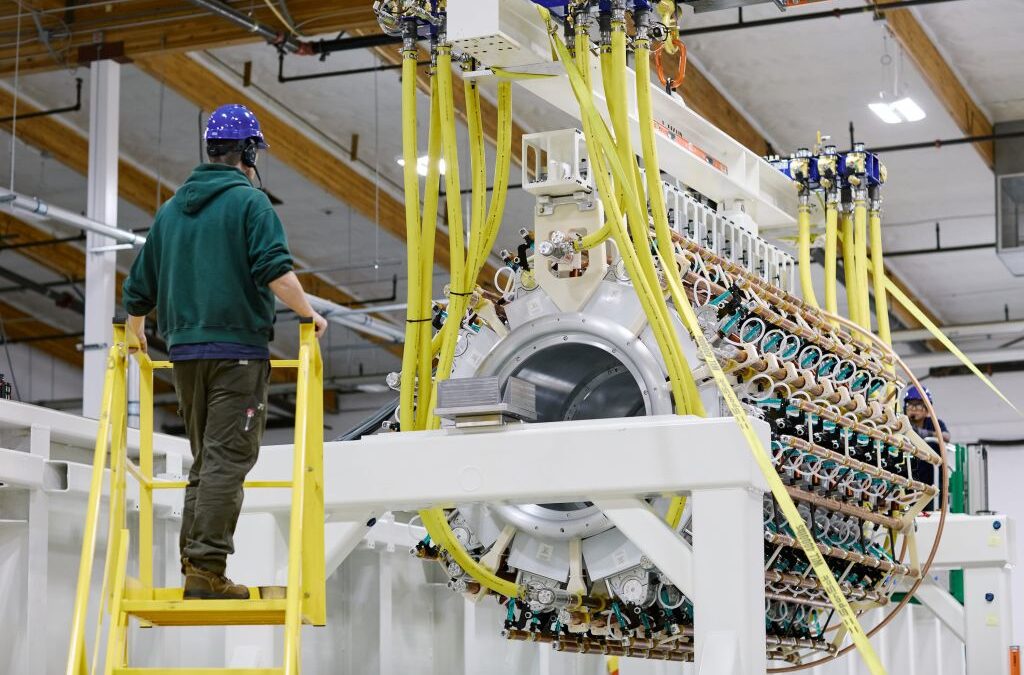 A Pacific Fusion employee inspects a pulser prototype.