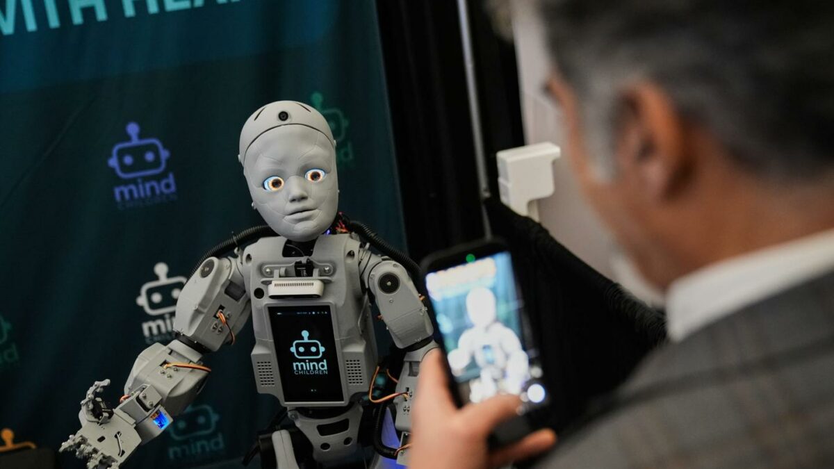A man records a humanoid robot inside the exhibition room at the Humanoids Summit, Thursday, Dec. 11, 2025, in Mountain View, Calif.