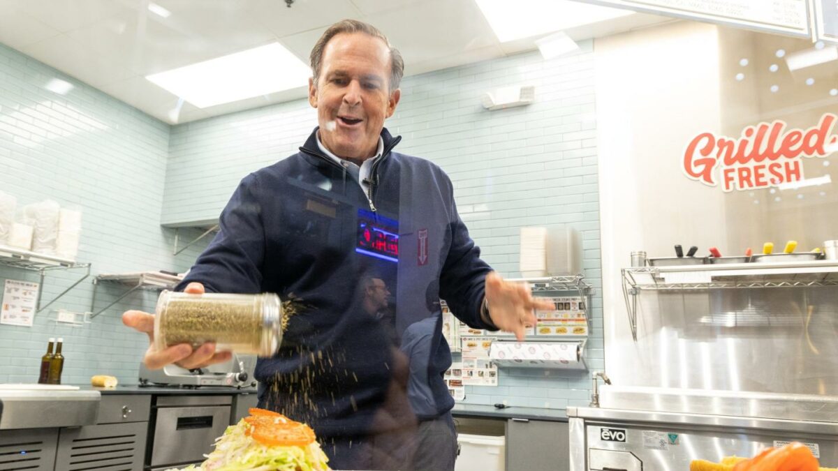 Peter Cancro shakes oregano over an open sandwich.