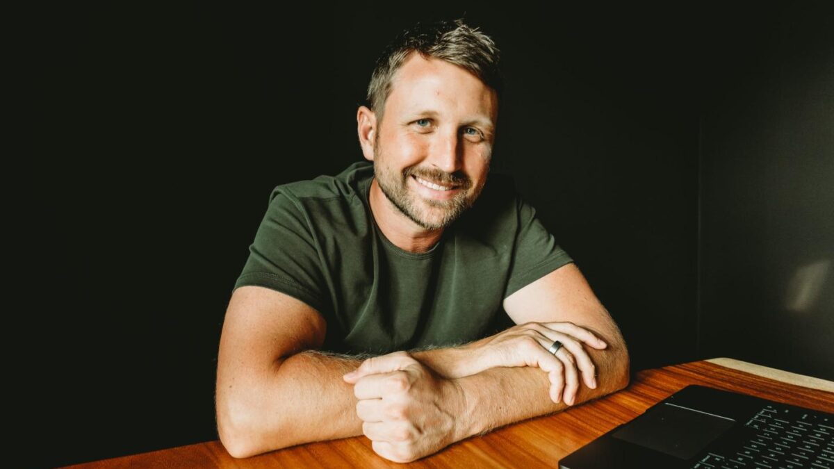 A headshot of Shane Mac smiling.