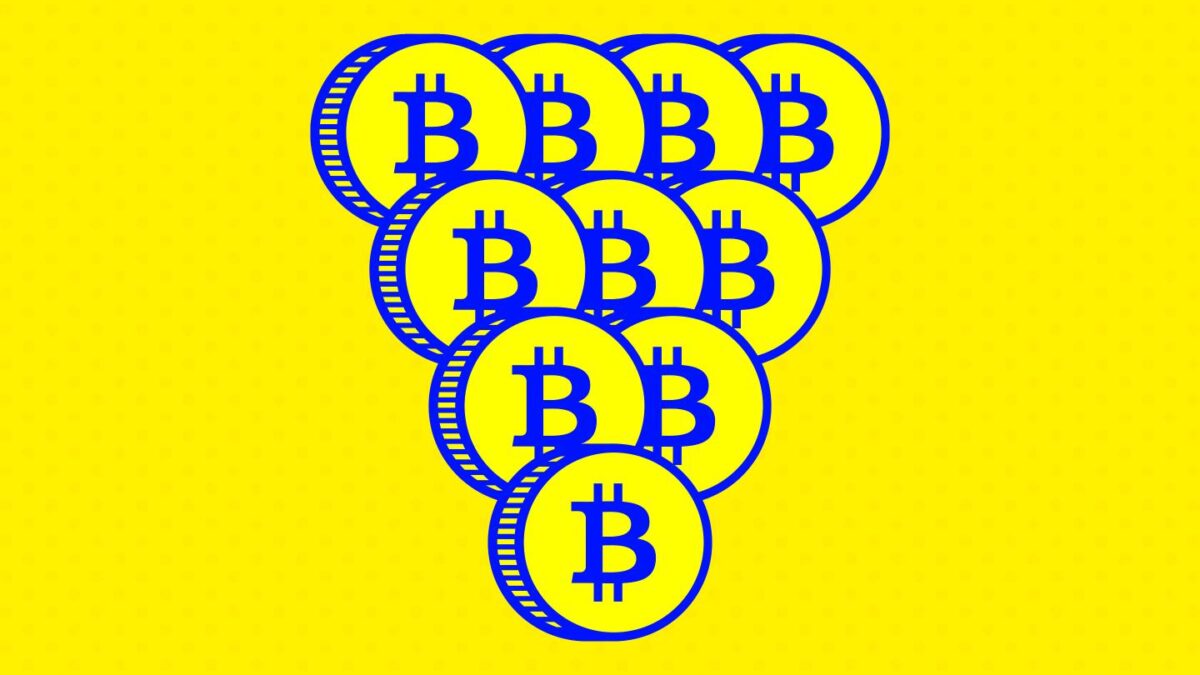 Coins with the Bitcoin logo imprinted on them stacked into a pyramid.