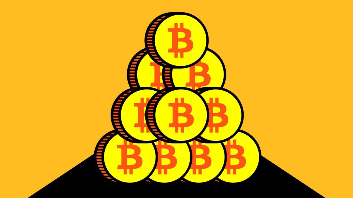 A picture of stacks of coins with the Bitcoin logo.