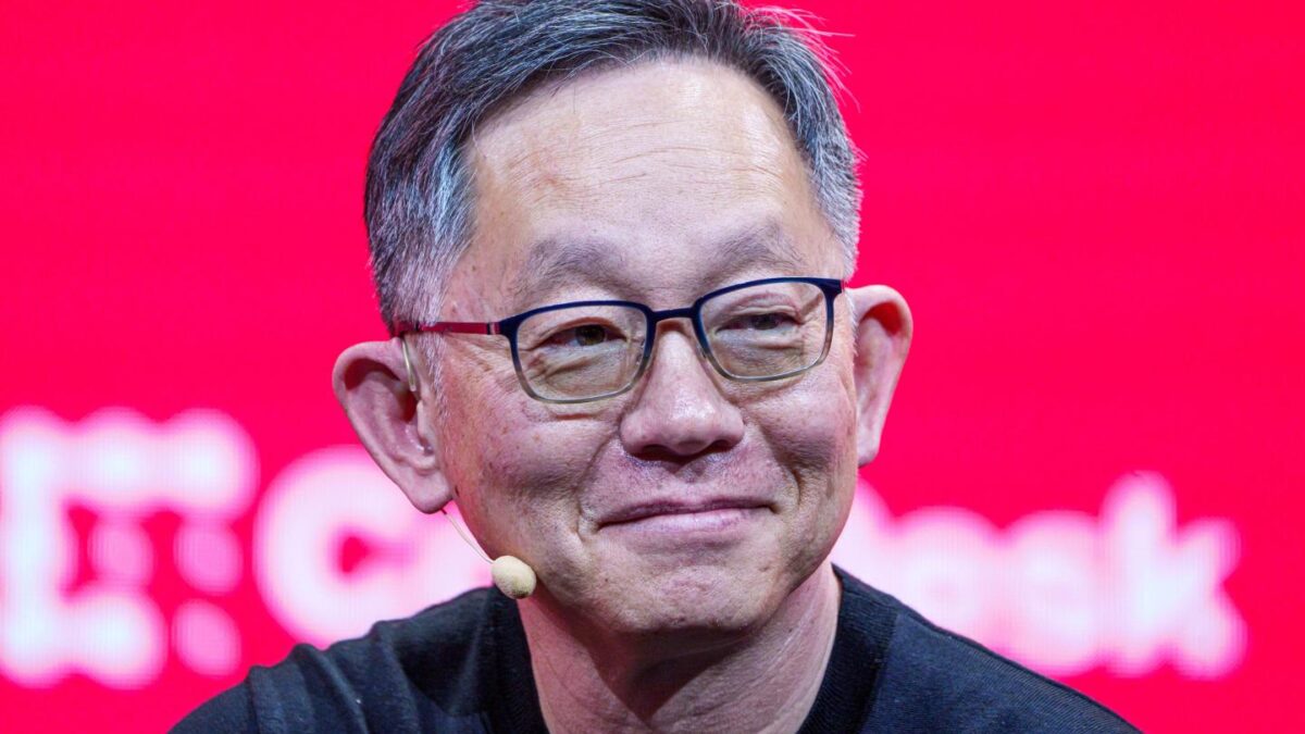 Evan Cheng smiles on stage at a crypto conference.